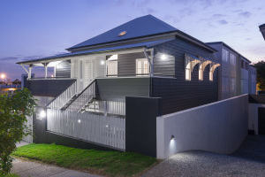 Two storey house surrounded by front white and grey fence